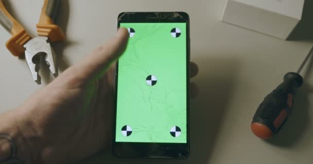 Tjekker telefon med brudt skærm, smartphone med grøn skærm og rulning – Stock-video