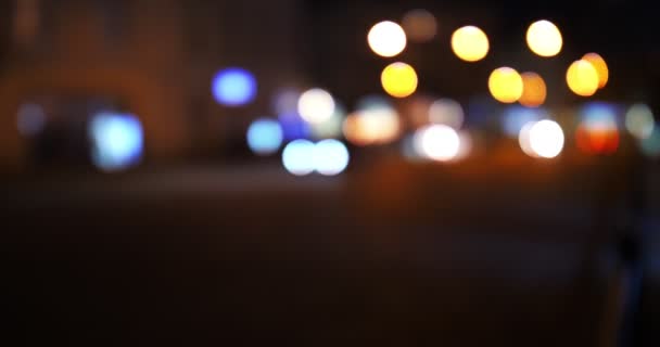 Luces de tráfico desenfocadas de la ciudad nocturna. Color Bokeh borroso de transporte en movimiento y ruido típico de la ciudad . — Vídeos de Stock