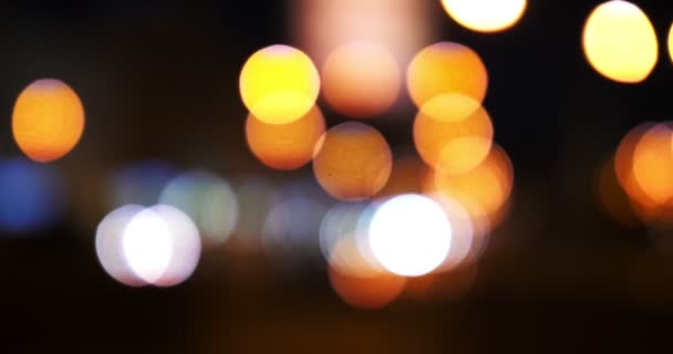 Luces de tráfico desenfocadas de la ciudad nocturna. Color Bokeh borroso de transporte en movimiento y ruido típico de la ciudad . — Vídeos de Stock