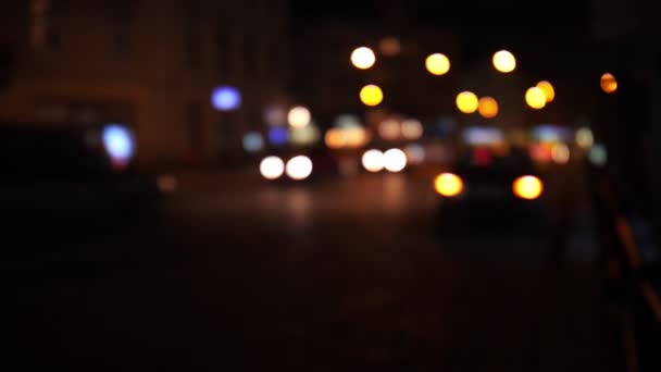 Luces de tráfico desenfocadas de la ciudad nocturna. Color Bokeh borroso de transporte en movimiento y ruido típico de la ciudad . — Vídeos de Stock