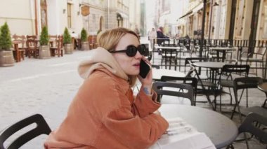 Kızlar kahve dükkanında toplama ve konuşan telefon