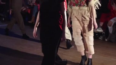 Kadın modelleri bir moda gösterisi sırasında farklı elbiseler pist yürümek. Moda podyum olay giysi yeni koleksiyonu gösteren. Bir satırda. 4k