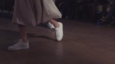 Kadın modelleri bir moda gösterisi sırasında farklı elbiseler pist yürümek. Moda podyum olay giysi yeni koleksiyonu gösteren. Bir satırda. 4k