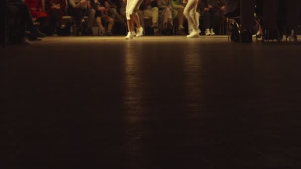 Τα θηλυκά μοντέλα περπατούν στο διάδρομο με διαφορετικά φορέματα κατά τη διάρκεια μιας εκπομπής μόδας. Εκδήλωση πασαρέλας μόδας που δείχνει νέα συλλογή ρούχων. Στη σειρά. 4K — Αρχείο Βίντεο