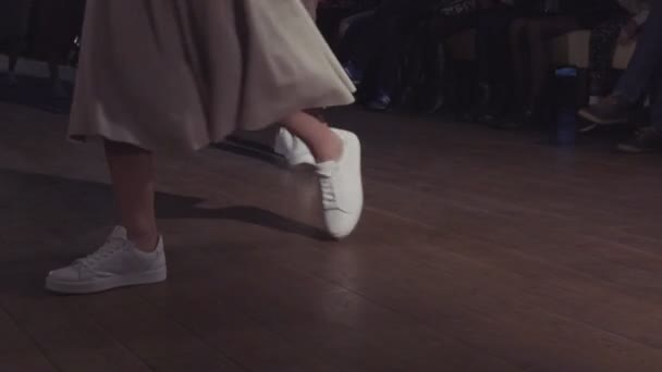 Las modelos femeninas caminan por la pasarela en diferentes vestidos durante un desfile de moda. Evento de pasarela de moda que muestra nueva colección de ropa. En una fila. 4k — Vídeo de stock