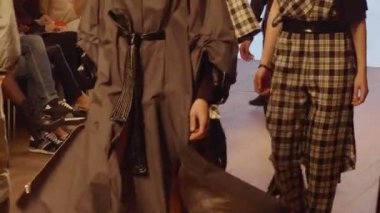 Kadın modelleri bir moda gösterisi sırasında farklı elbiseler pist yürümek. Moda podyum olay giysi yeni koleksiyonu gösteren. Bir satırda. 4k