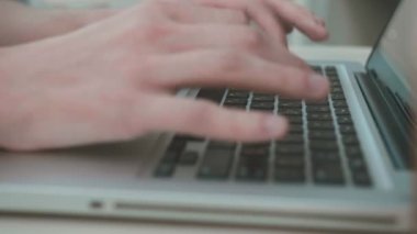 Bilgisayarın klavyesinde daktilo eden adam, yakın plan. Yan görüş. Ağır çekimde çekmek