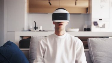 VR aygıtı kullanan genç beyaz adamın yavaş çekim sahnesi. Eğlenceli sanal bilgisayar veya video oyunları heyecan verici.