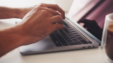 Ofis masasında çalışırken dizüstü bilgisayarda daktilo yazan tanınmayan iş adamının yakın çekim görüntüleri. 