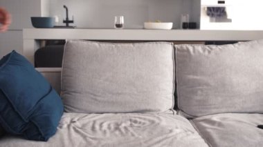 Yorgun, genç, beyaz bir adam yorucu bir çalışmadan sonra oturma odasında kanepede oturuyor. 4k ağır çekim görüntüleri.