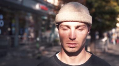 Portre yüzü beyaz bir adam kameraya bakıyor. Şehir şehrinde eğleniyor. Yakışıklı, kendine güvenen, kenar mahalle cazibesi.. 