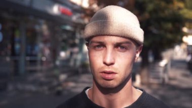 Ciddi bir portre, beyaz bir adam kameraya bakıyor. Şehir şehrinde eğleniyor. Yakışıklı, kendine güvenen, kendine güvenen, kenar mahalle cazibesi.. 