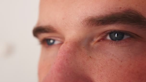 Ojos de un hombre caucásico. vista de cerca de una persona cara. El hombre está mirando a la cámara. La mirada de los hombres mira hacia el futuro. — Vídeos de Stock