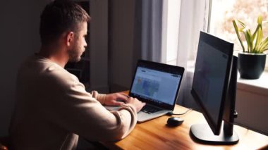 İşadamı odaklı girişimci dizüstü bilgisayarla araştırma yapıyor. Bilgisayarı kullanan genç profesyonel bir erkek ofis masasında oturuyor. Modern teknoloji not defteri üzerinde çalışan meşgul bir işçi..