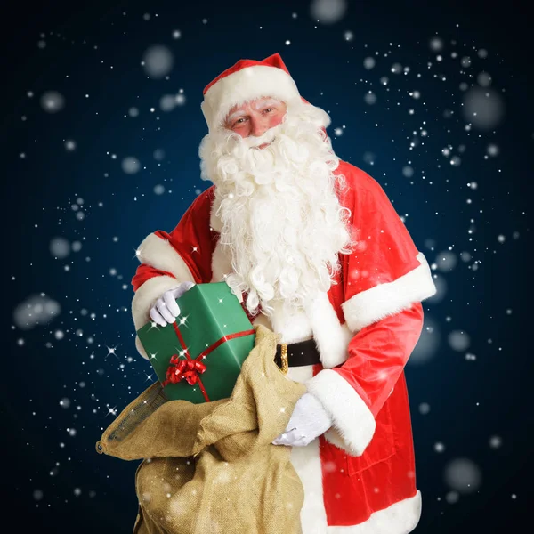 Noel Baba gülümseyerek teslim etmek büyük kahverengi bir çanta hediye.
