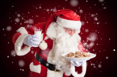 Noel Baba Noel arifesi süt ve kurabiye hakkında mutludur.