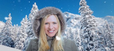 Karlı kış manzarası ile yüksek bulutlar ve gülümseyen bir çekici kadın ön planda.