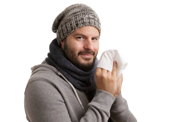 一个人在冬天的时候有疾病的打喷嚏和吹成手帕隔离在白色背景 — 图库照片