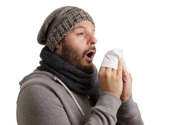 一个人在冬天的时候有疾病的打喷嚏和吹成手帕隔离在白色背景 — 图库照片