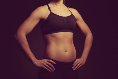Koyu arka plan üzerinde genç sportif kadın