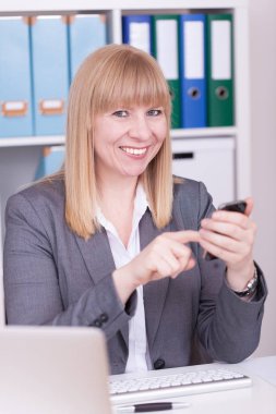 Akıllı telefon kullanan genç bir iş kadını