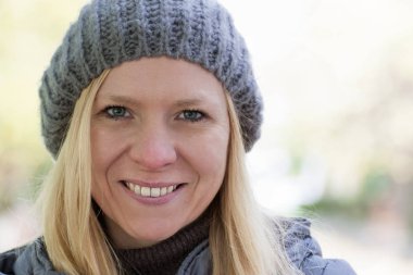 Orta yaşlı beyaz kadın kameraya gülümsüyor