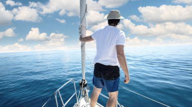 Bir geminin yay içinde duran adam. Yatçılık, tatil ve freedo