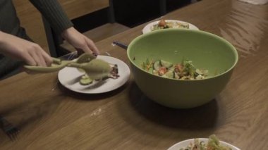 Kadın sebze salatası onun plaka koyar.