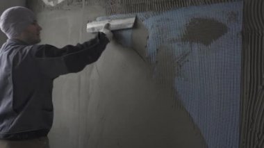 Bir adam bir duvar bir spatula ile su sıçramalarına