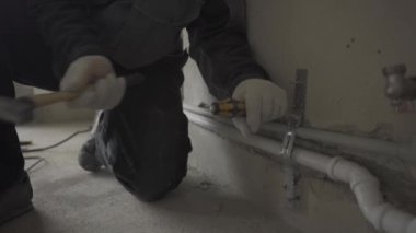 Borular bir tornavida ve duvara bir çekiç ile kafasına bandana ile üniformalı Oluşturucusu takılır