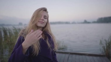 Genç bir kadın onu göle iskele boyunca arka planda takip etmeye çağırır