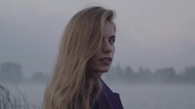 Kamera ve uzak eliyle onun saç düzleştirme görünüyor bakarak gülümser dönüm kadın