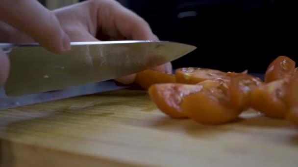 Man plakjes tomaten op een houten bord — Stockvideo