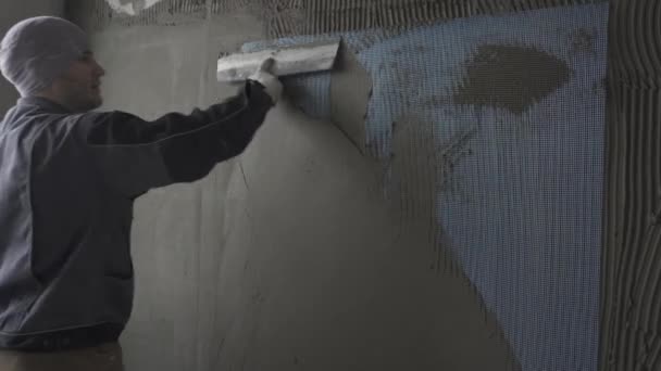 Mann bespritzt Wand mit Spachtel — Stockvideo