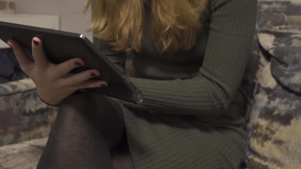 Femme aux cheveux longs assise dans la tablette — Video
