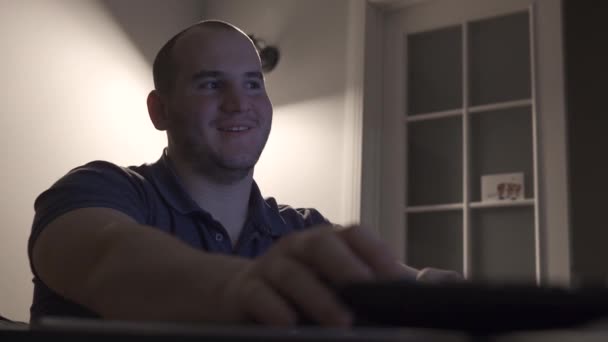 Vrolijke man glimlacht en toont een vriend in de monitor — Stockvideo