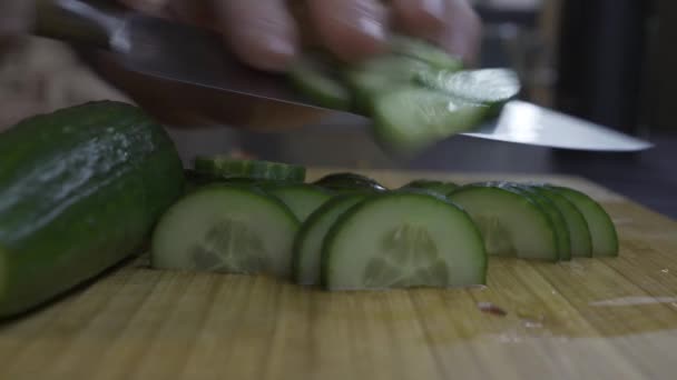 Man plakjes komkommer in plakjes — Stockvideo