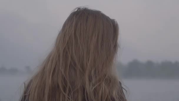 Kvinna står på bakgrunden av sjön med dimma — Stockvideo