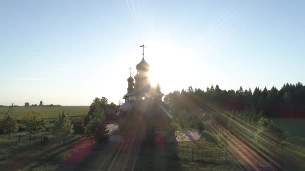 Aerial flight over the church, due to which the sun appears — Stock Video