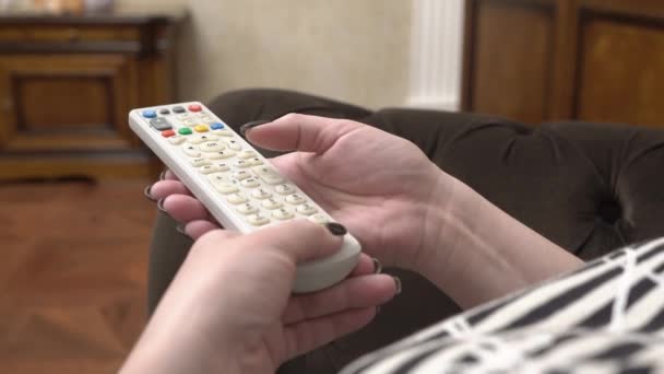 Mujer presiona los botones en el control remoto — Vídeo de stock