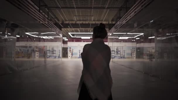 Молодая красивая женщина гуляет одна в закрытом торговом центре — стоковое видео