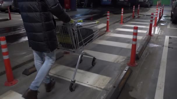 На парковке: Человек толкает корзину — стоковое видео