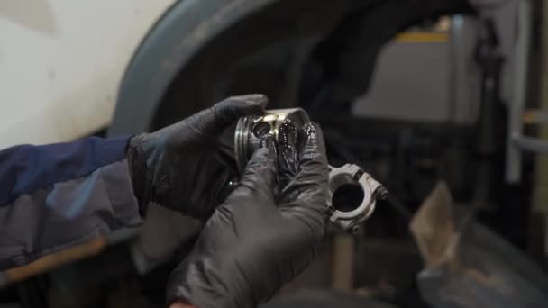 Механик держит поршень двигателя — стоковое видео