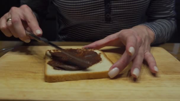 Closeup video: verspreiding van chocolade boter op een stukje brood — Stockvideo