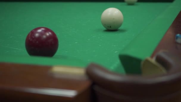 Egy férfi biliárd játék megüt egy bordó golyót, és fehér szerzett a zsebében — Stock videók