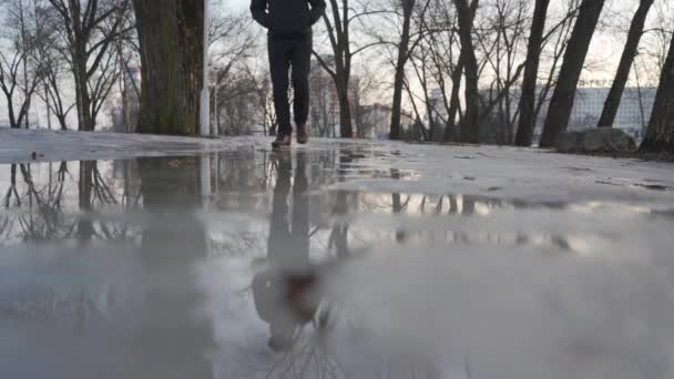 Um homem anda na primavera derretendo neve — Vídeo de Stock