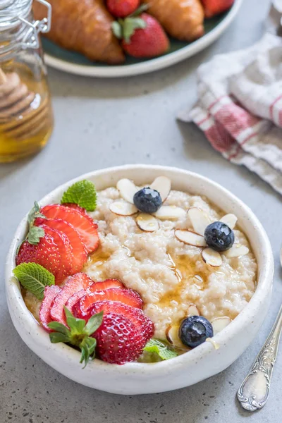 Porridge di farina d'avena tagliata in acciaio con fragola e mirtillo per colazione — Foto Stock