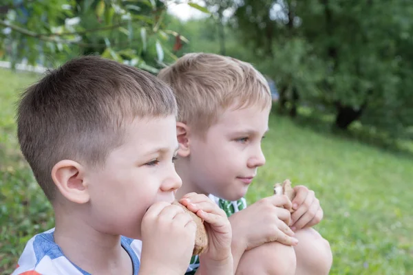 Boy outdoors eating a sandwich — Stock Photo, Image