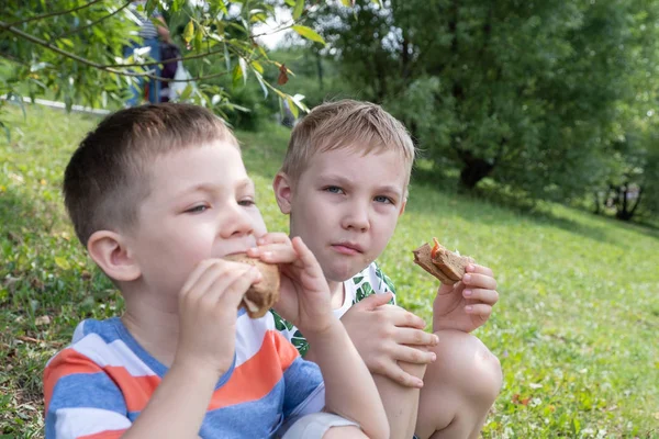 Jongen buitenshuis eten van een boterham — Stockfoto