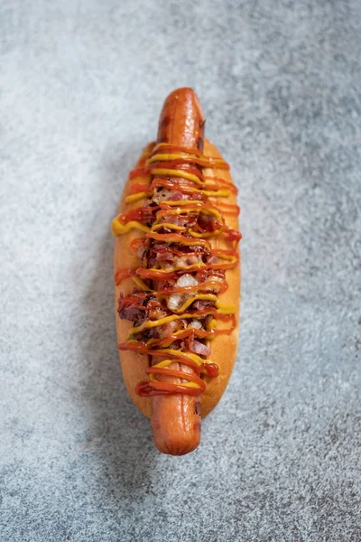 Cachorro quente com mostarda amarela, cebola, bacon — Fotografia de Stock